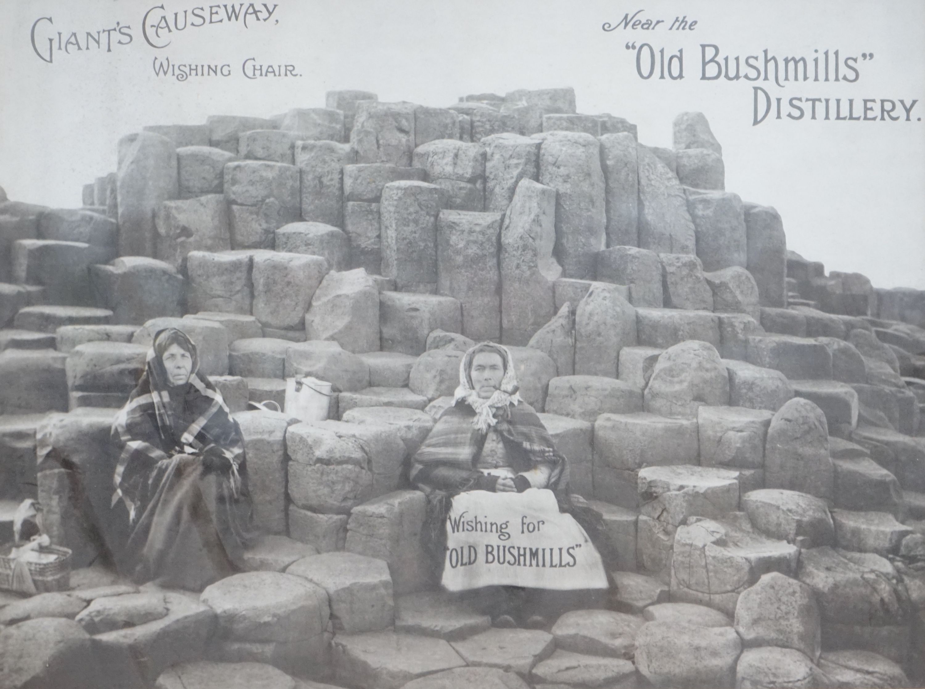 A monochrome advertising print for Old Bushmills Distillery, Giants Causeway, Wishing Chair, 39 x 52cm